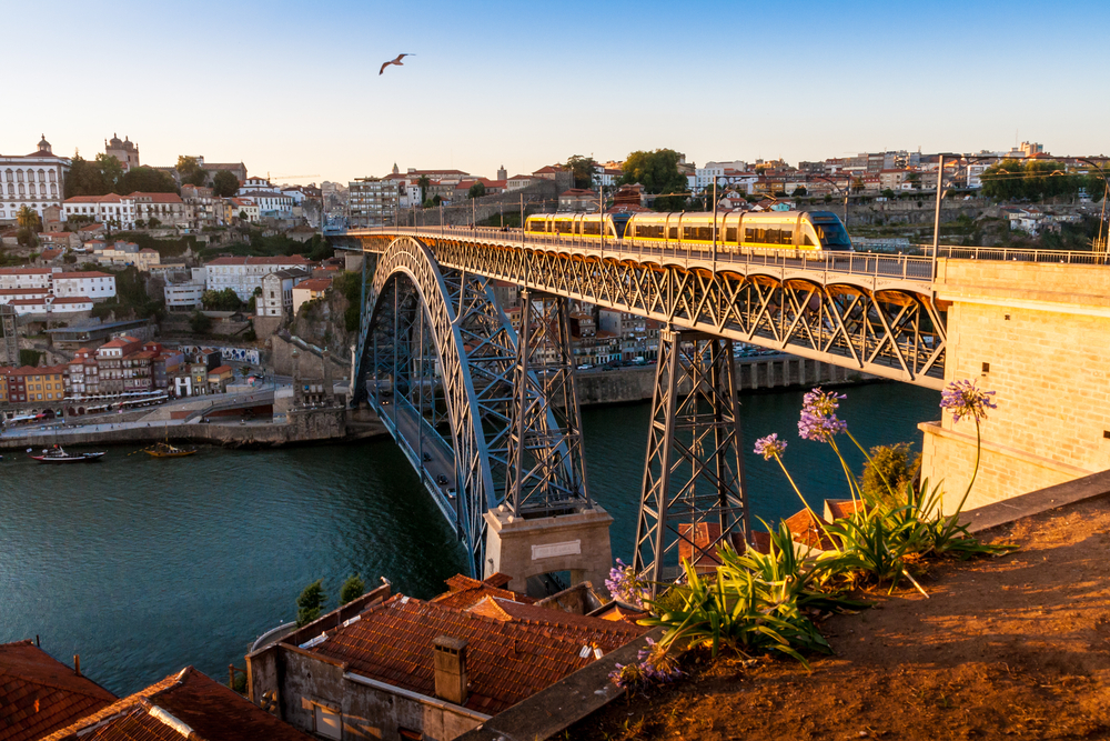 Dom Luis I Bridge in Porto at sunset with metro train