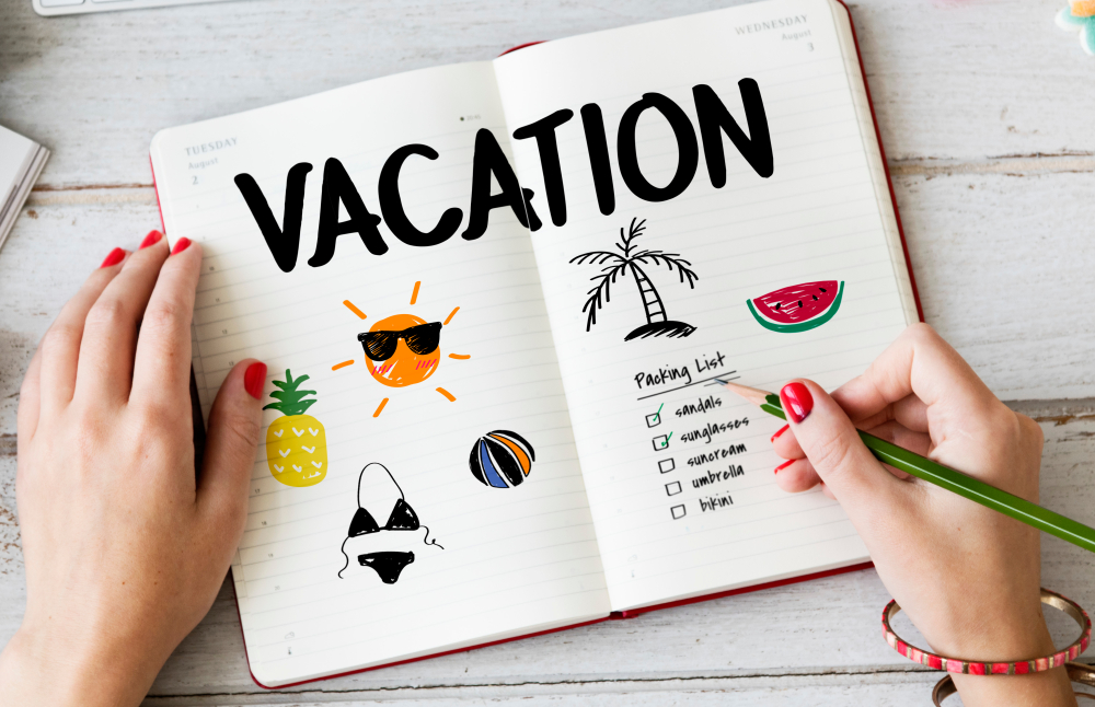 Woman writing packing list for summer vacation