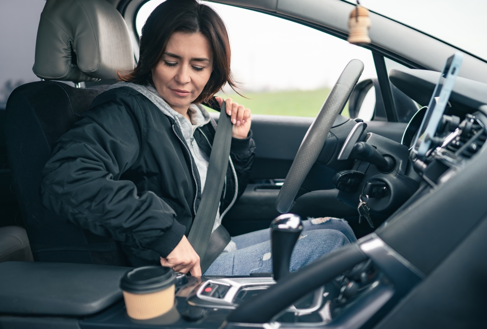 Woman Prepares For A Long Car Trip And Fastens Seatbelt