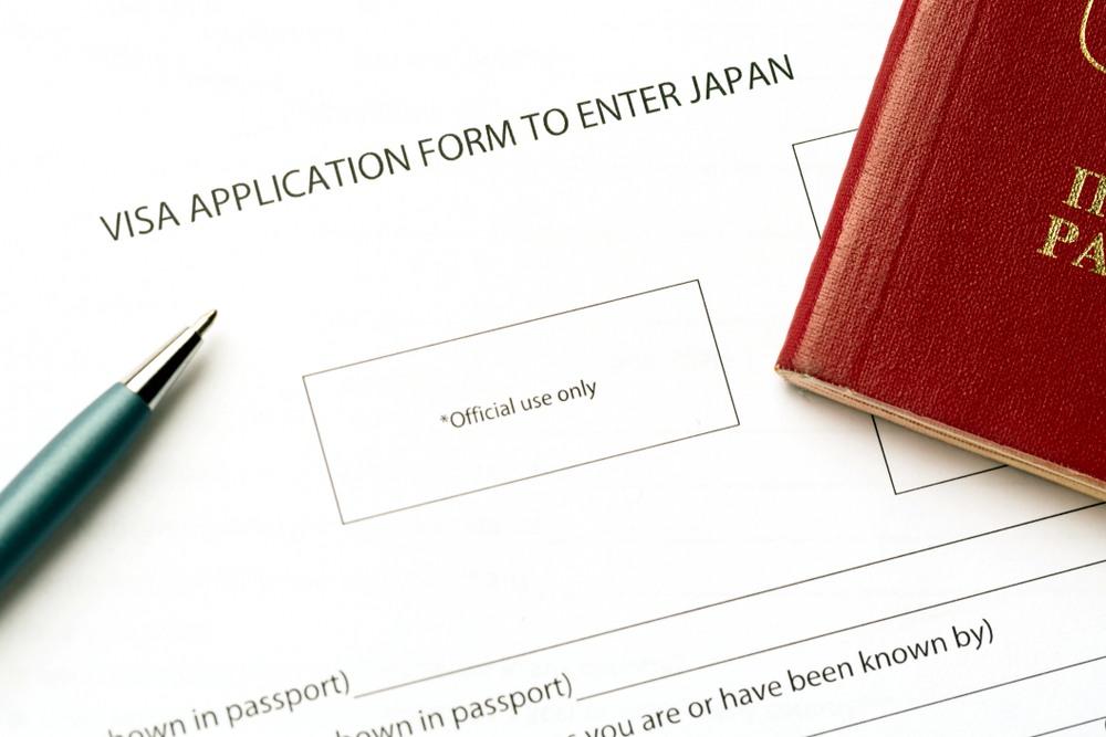 Pen and passport on blank Japan visa application form. Tourism and travel in Japan concept.