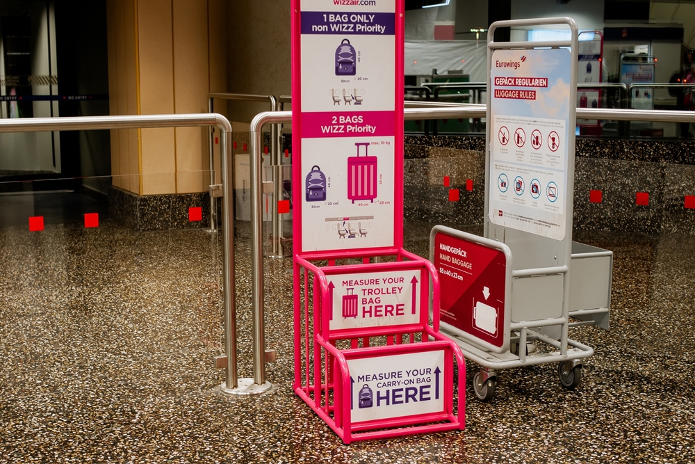 Wizz Air and Eurowings Luggage Sizing and Rule Stands in Bright Pink and Red at a Check in Area of Milan Malpensa Airport on October 2, 2025