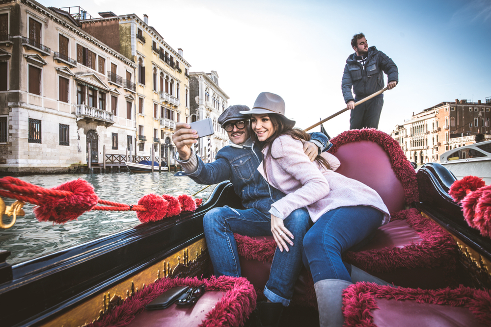 Couple of lovers on vacation in Venice, Italy - Tourists having a trip on a venetian gondola