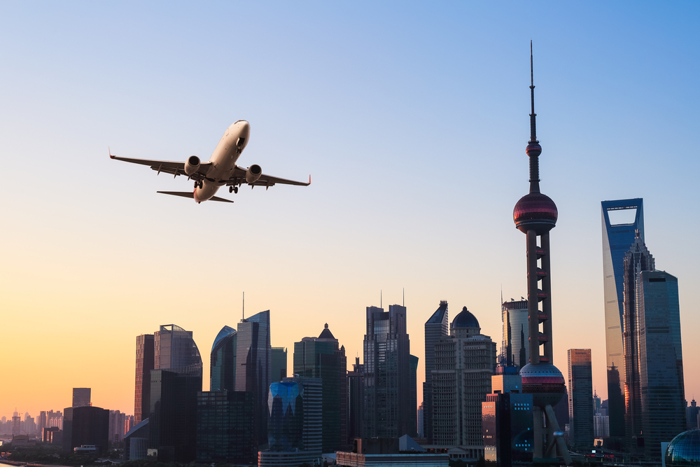 shanghai modern buildings skyline with airplane in sunrise