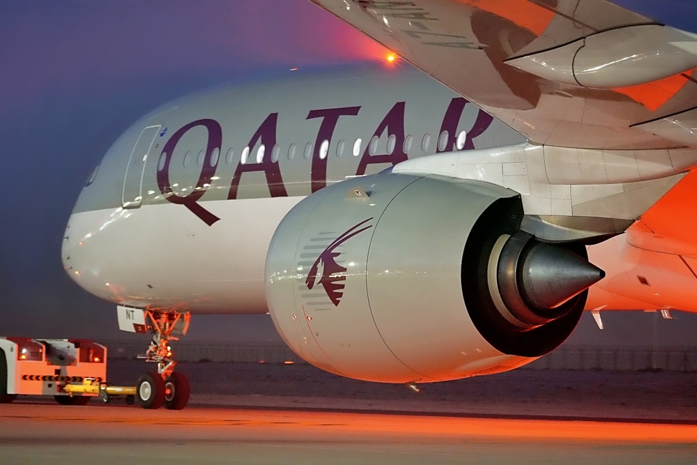 A Qatar Airways A350 is tugged to its display location at the 2023 Dubai Airshow at dusk