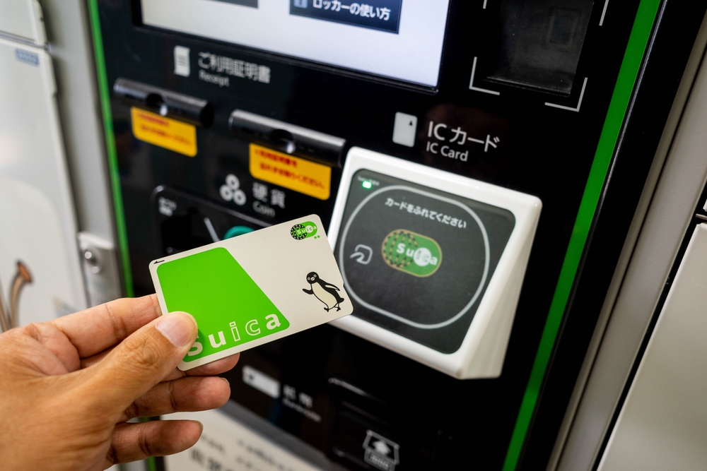 Close up of a hand holding a SUICA electronic money card in front of a sensor to make payment for a purchase at Nagano, Japan.