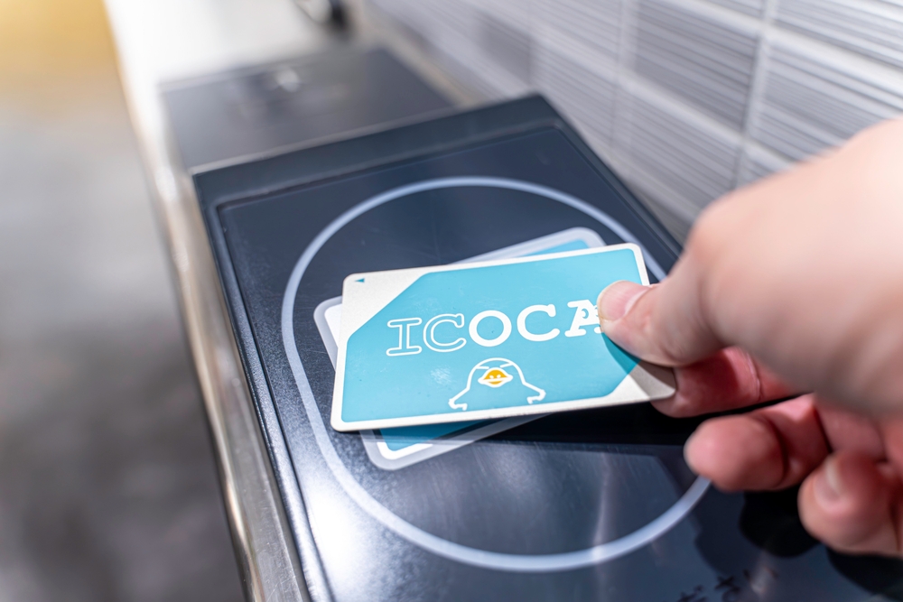  Closeup hand of people using Japan IC card "ICOCA" touch and pay at entrance automatic ticket machines at Kyoto subway station.